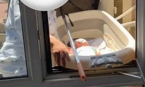 Mẹ mang con ra ngoài cửa sổ tầng cao để "phơi nắng trị vàng da", cư dân mạng hoảng hốt